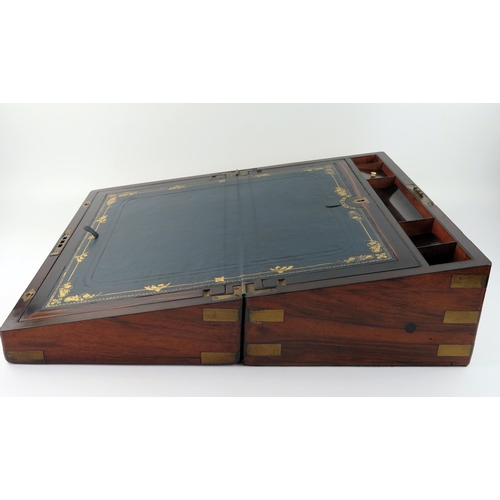 1570 - A Victorian walnut and brass bound campaign writing slope, the hinged lid enclosing a tooled leather... 