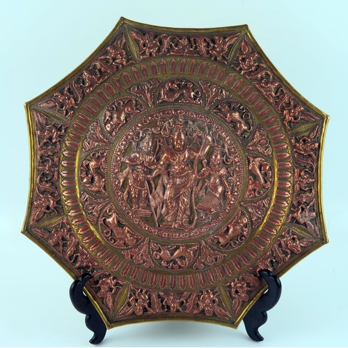 1603 - An Indian brass and copper octagonal plate, decorated in low relief with deities, animals and mythic... 