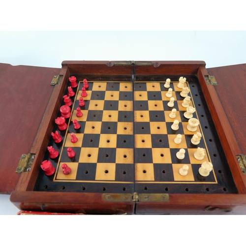 1652 - A travelling chess set, with natural and stained red bone chess pieces contained in a mahogany foldi... 