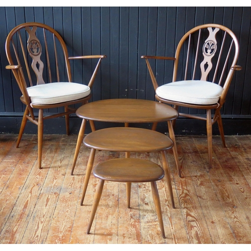 1785 - A pair of Ercol Fleur d'Lys Windsor chairs with arched back, swept arm supports and solid seat on tu... 