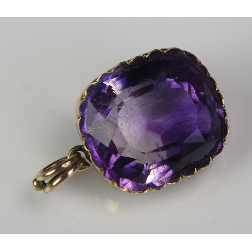 21 - An Antique Amethyst Pendant in an unmarked gold setting, the 18.5x16.2mm stone with clear and purple... 