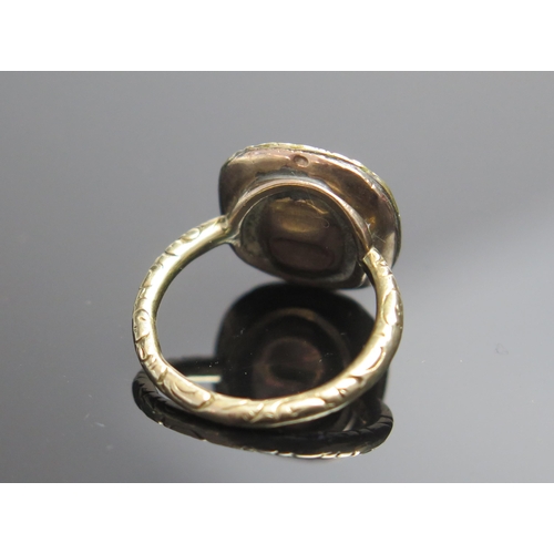 68 - A Georgian Unmarked Gold and Foil Backed White Hardstone Ring with chased foliate decoration to the ... 