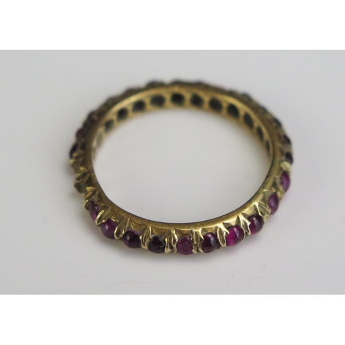 69 - A 19th Century Cabochon Garnet Eternity Ring in an unmarked high carat gold setting, 3mm wide, size ... 