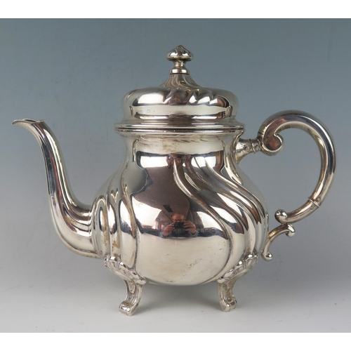 1 - A German silver circular teapot, stamped marks, of ovoid writhen form, with scroll handle, and raise... 