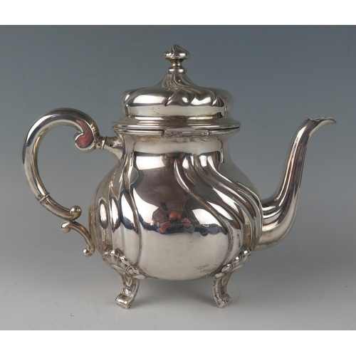 1 - A German silver circular teapot, stamped marks, of ovoid writhen form, with scroll handle, and raise... 