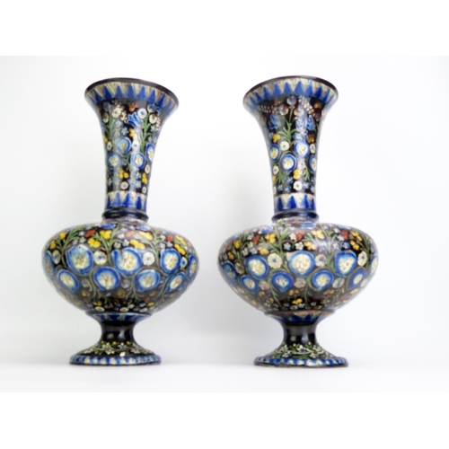 1068 - A pair of Alhambra faience vases, with trumpet-shaped necks, bulbous bodies on spreading circular fe... 