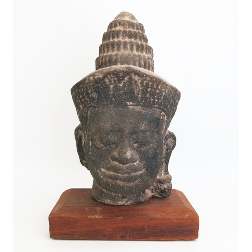 1154 - A Burmese reconstituted stone head of Buddha, mounted on a polished wood stand, overall height 42cm ... 