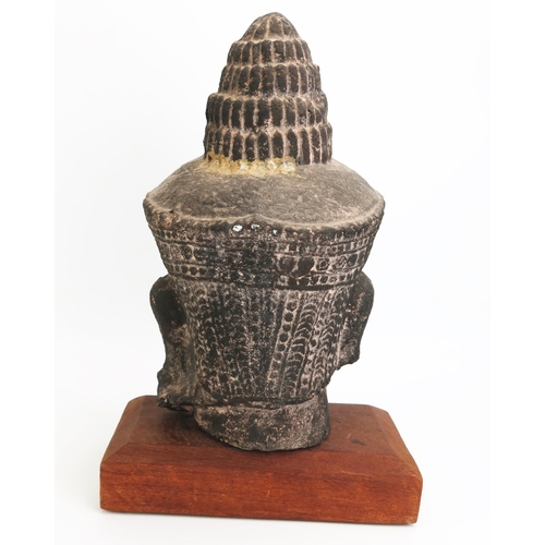 1154 - A Burmese reconstituted stone head of Buddha, mounted on a polished wood stand, overall height 42cm ... 