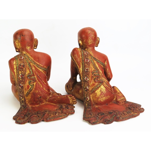 1156 - Two Southeast Asian carved wood , gilt and paste set figures of praying and crouching monks, dressed... 