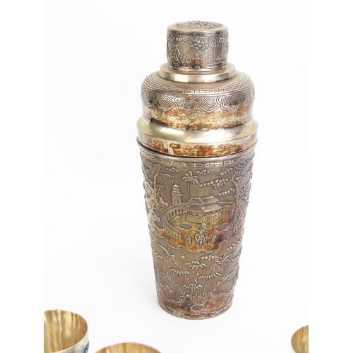 1158 - An Oriental white metal cocktail shaker, decorated with figures in a village scene, with pull-off li... 