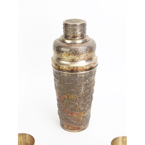 1158 - An Oriental white metal cocktail shaker, decorated with figures in a village scene, with pull-off li... 