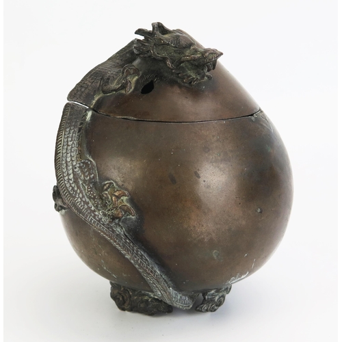 1178 - A Chinese bronze censer and cover of ovoid form, surmounted by a dragon raised on three foliate feet... 