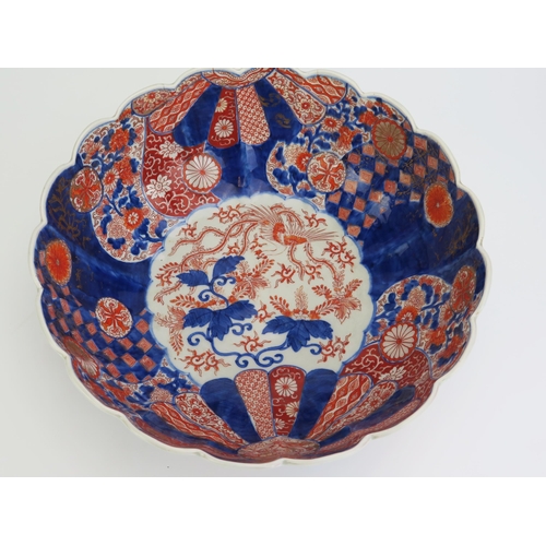 1179 - A large Imari porcelain bowl of lobed form, decorated with phoenix bird, fan and flowerhead decorati... 