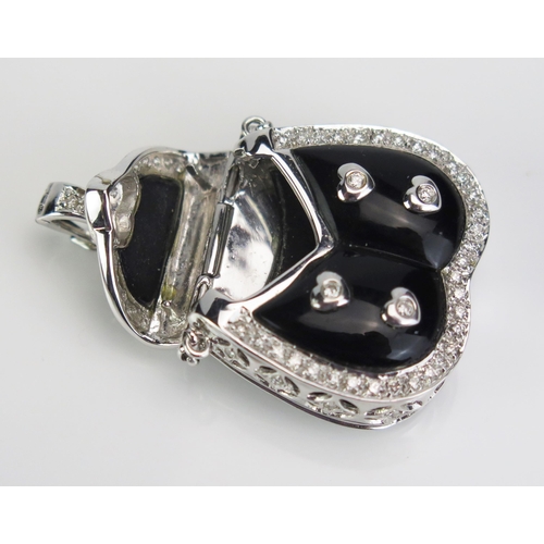 124 - An 18ct White Gold, Diamond and Black Enamel Pendant in the form of a handbag with hinged cover open... 