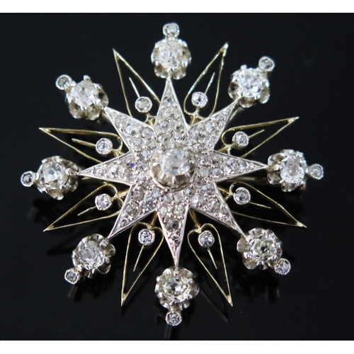 A Diamond Star Brooch with pendant mount in an unmarked precious yellow and white metal setting, old cushion cut stones (largest c. 4mm), 40mm diam., KEE tested as 18ct, c. 15.63g, presented in a Page Keen & page of Plymouth box. Early 20th century