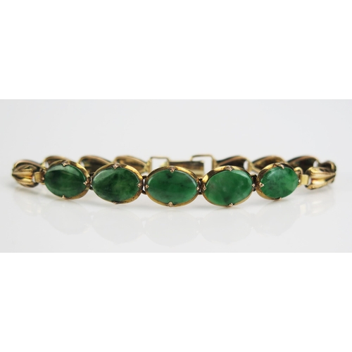 65 - A Jadeite Bracelet set with five 10.5x7mm oval cuts in an unmarked gold setting, c. 6.5