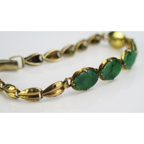 65 - A Jadeite Bracelet set with five 10.5x7mm oval cuts in an unmarked gold setting, c. 6.5