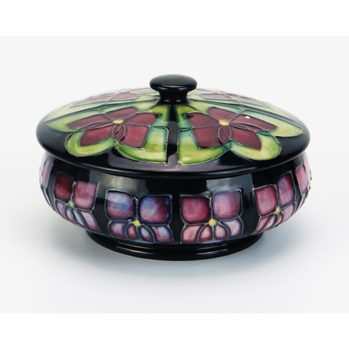 1013 - A Moorcroft pottery pot and cover with 'Violet' decoration, by Rachel Bishop, 13cm diameter.