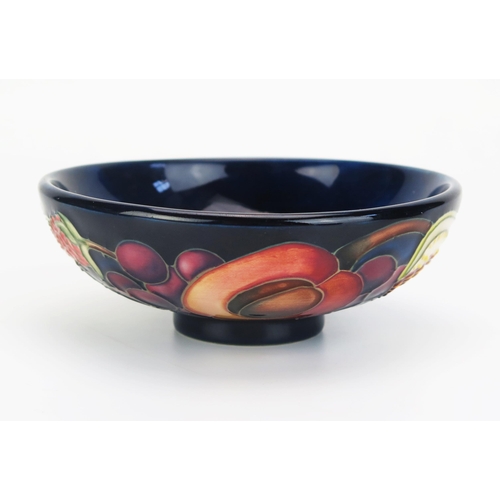 1014 - A Moorcroft pottery dish with 'Queens Choice' pattern by Emma Bossom, 12cm diameter.