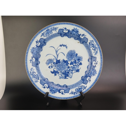 1068 - A Chinese blue and white plate the centre decorated with chrysanthemums enclosed by scrolls and flor... 