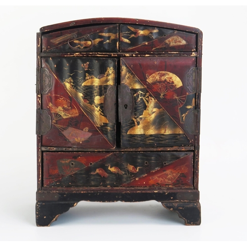 1082 - A Japanese lacquered kodansu, of arched outline, with two short drawers above a pair of cupboard doo... 