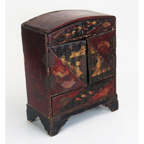 1082 - A Japanese lacquered kodansu, of arched outline, with two short drawers above a pair of cupboard doo... 