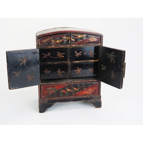 1082 - A Japanese lacquered kodansu, of arched outline, with two short drawers above a pair of cupboard doo... 