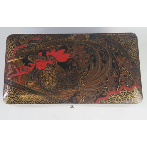 1087 - A Japanese lacquered tebako, of rectangular outline, the lift-off lid decorated with a strutting coc... 