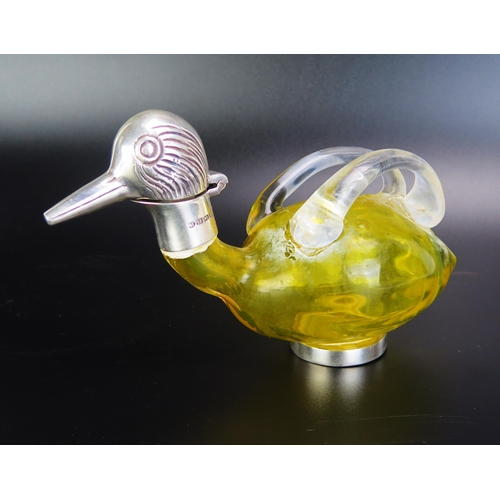 1093 - A yellow glass and silver plate mounted  oil bottle in the form of a duck with hinged head with loop... 