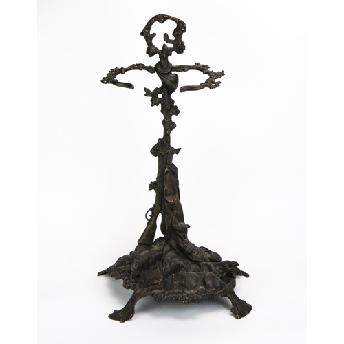 1101 - A cast metal stick stand, the foliate stem with loop handle having hunting horn, gun and dead hare d... 