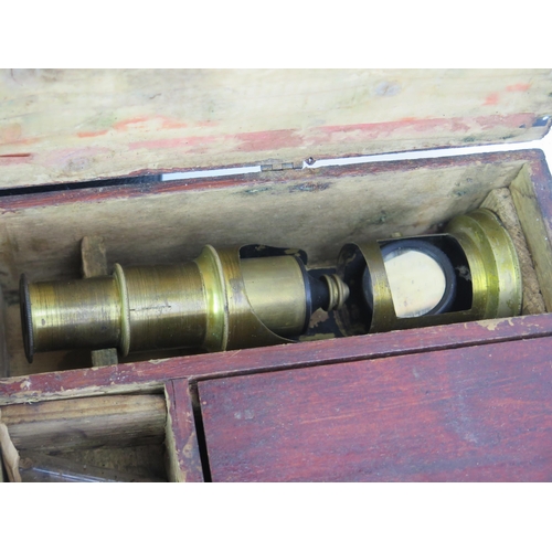 1112 - A 19th century lacquered brass field microscope, with single draw focussing, plano mirror, contained... 