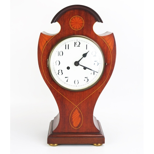 1113A - An Edwardian mahogany and inlaid mantel clock, of broken balloon shaped outline, inlaid with fan and... 