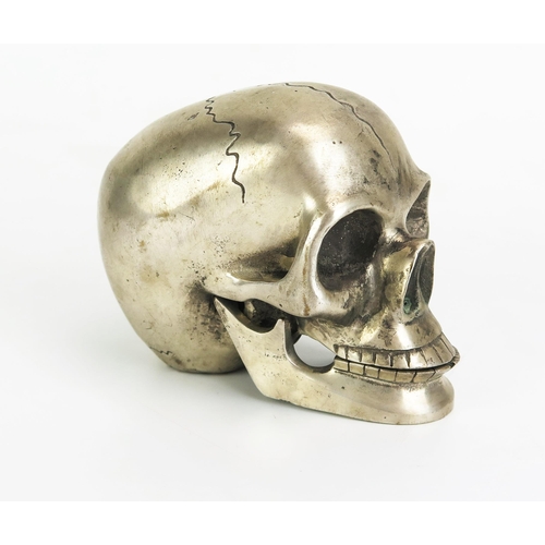 1126 - A metal paperweight in the form of a skull with hinged jaw, 12cm long.