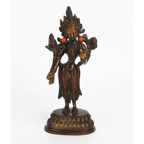 1150 - A bronze Buddhist statue of a female deity, inset with coral, standing on a lotus flower base, 16.5c... 