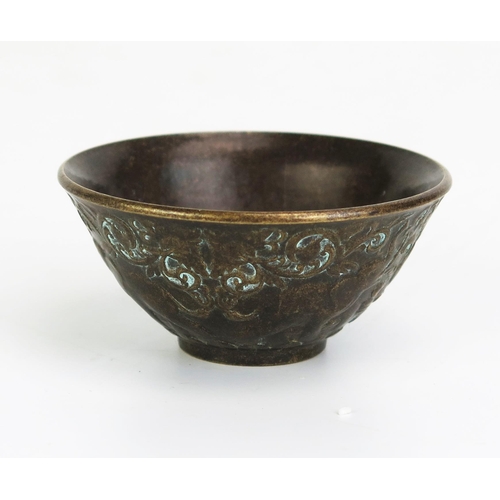 1152 - A bronze Buddhist wine cup of circular form with banded elephant decoration on a circular foot, 6cm ... 