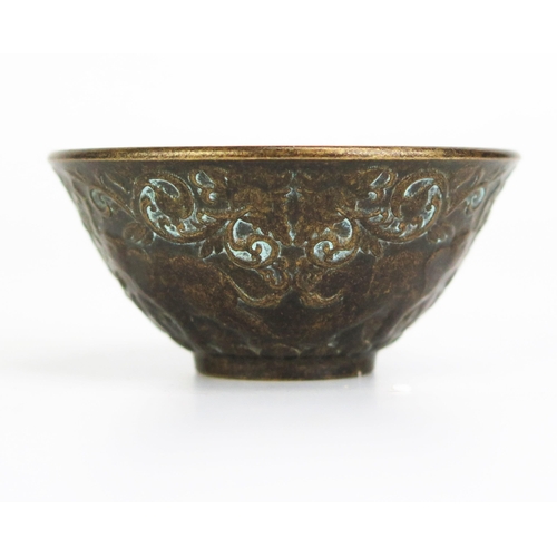 1152 - A bronze Buddhist wine cup of circular form with banded elephant decoration on a circular foot, 6cm ... 