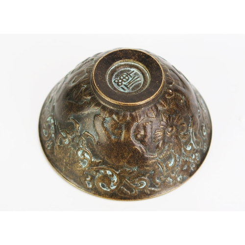 1152 - A bronze Buddhist wine cup of circular form with banded elephant decoration on a circular foot, 6cm ... 