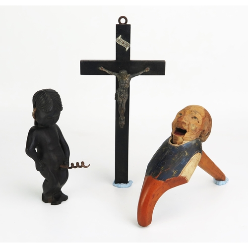 1156 - A German carved wooden figural nutcracker, a crucifix and figural bottle opener