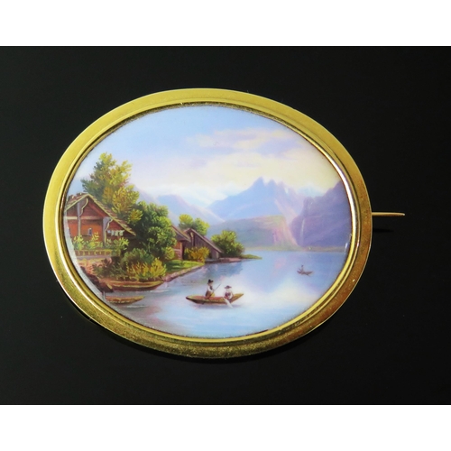 129 - An Antique Geneva Enamel Oval Brooch decorated with a lakeside scene in a precious yellow setting, 4... 