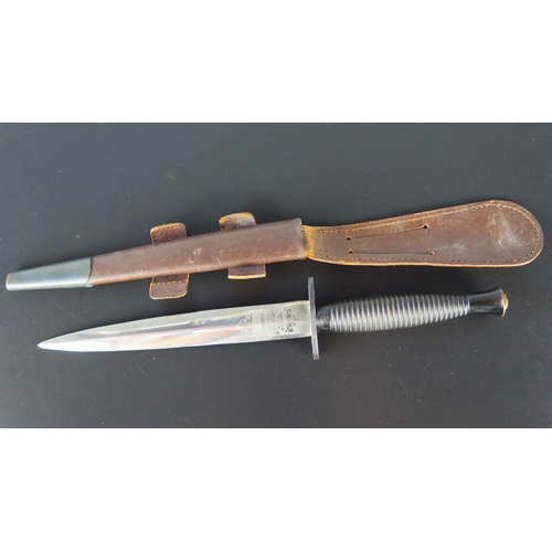 A Fairbairn Sykes fighting knife by Wilkinson Sword, with 17cm double edged blade, straight cross guard, ribbed grip contained in its original leather sheath