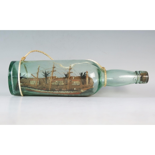 1329 - A model of a three-masted ship in a bottle, overall length 31cm.