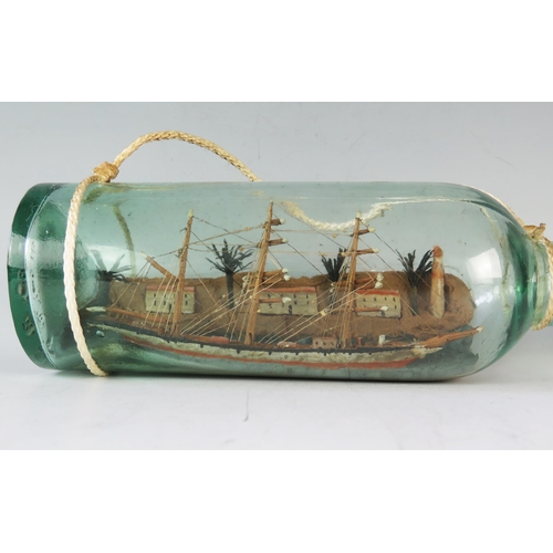 1329 - A model of a three-masted ship in a bottle, overall length 31cm.