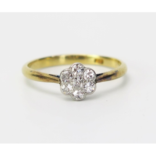 140 - An 18ct Gold and Diamond Flower Head Cluster Ring with seven c. 2mm millegrain set stones, stamped 1... 