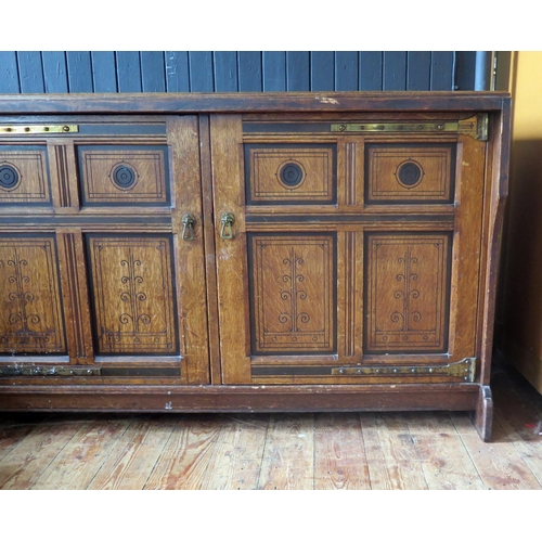 1411 - An aesthetic movement period oak side cupboard, the rectangular top with a moulded edge, above a pai... 