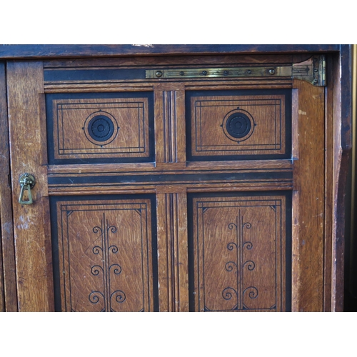 1411 - An aesthetic movement period oak side cupboard, the rectangular top with a moulded edge, above a pai... 