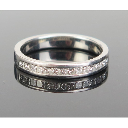 142 - A Platinum and Diamond Half Eternity Ring, with fourteen c. 2.4mm channel set princess cut stones, s... 