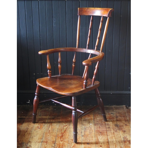 1421 - A late Georgian elm Windsor style elbow chair, with high comb back, solid seat on turned legs united... 