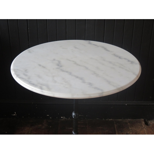 1423 - A marble topped Bistro or conservatory table, the circular top on a cast iron stem and tripod base, ... 