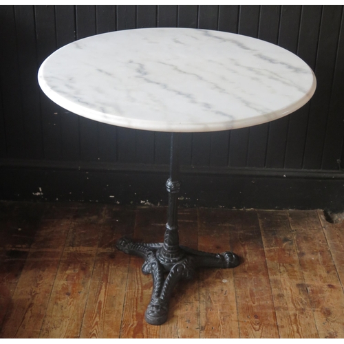 1423 - A marble topped Bistro or conservatory table, the circular top on a cast iron stem and tripod base, ... 