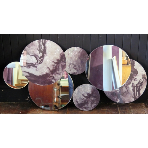 1430 - A modernist wall mirror, with three circular mirror plates, surrounded by four circular marbled effe... 